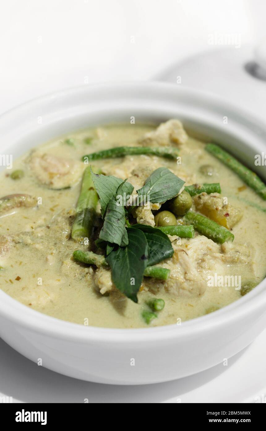 thailändisches grünes Curry mit Huhn und Gemüse auf weißem Tischhintergrund Stockfoto