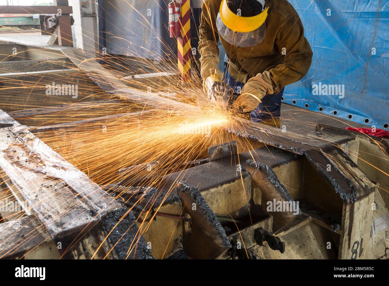 Arbeiten mit Schleifmaschine in einem LKW, Industriearbeiter Stockfoto