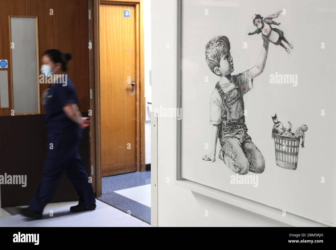 Eine Person geht an dem neuen Kunstwerk vorbei, das Banksy während der Sperrung gemalt hat und den Titel 'Game Changer' trägt. Dieses Kunstwerk wurde Mitarbeitern und Patienten auf Level C des Southampton General Hospital gezeigt. Stockfoto