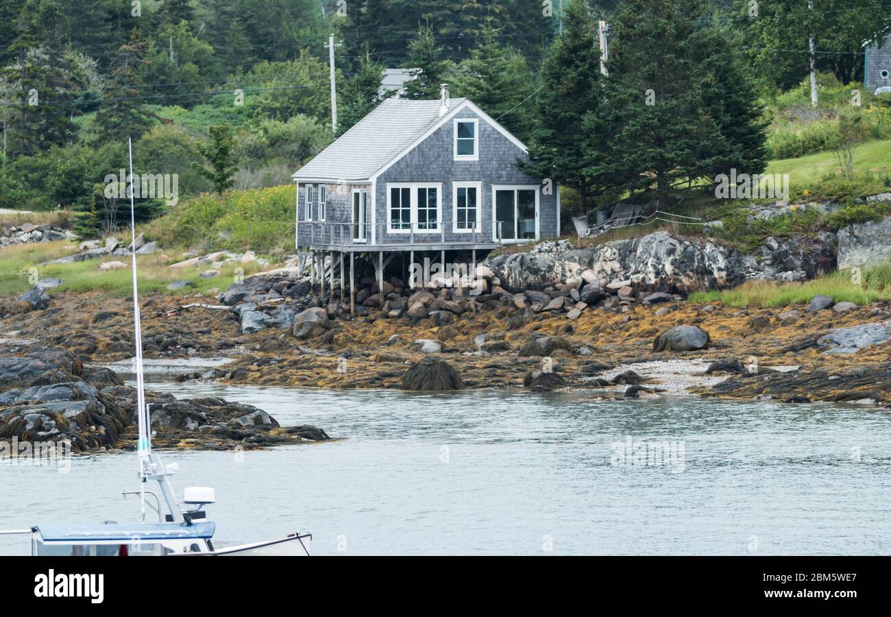 Ein Haus ist auf Stelzen am Wasser Rand in Vinalhaven Island Maine gebaut. Stockfoto