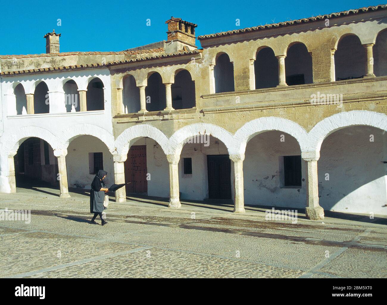 Alte Frau, die am Hauptplatz entlang läuft. Garrovillen, Provinz Caceres, Extremadura, Spanien. Stockfoto