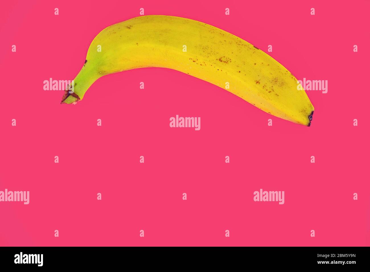 Gelbe Bananenform auf rosa Hintergrund. Banana Minimal. Pastellfarben. Popart. Digitalart: Surreal. Pop. Kreativ. Minimalistische Kunst. Banana Stockfoto