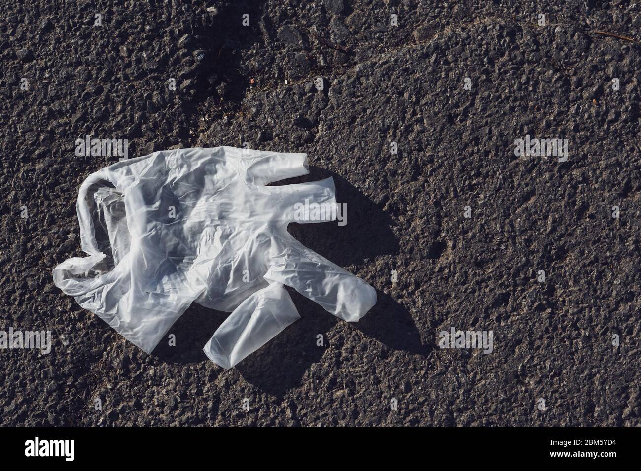 Medizinischer Schutzhandschuh aus Gummi, der auf dem Bürgersteig liegt Stockfoto