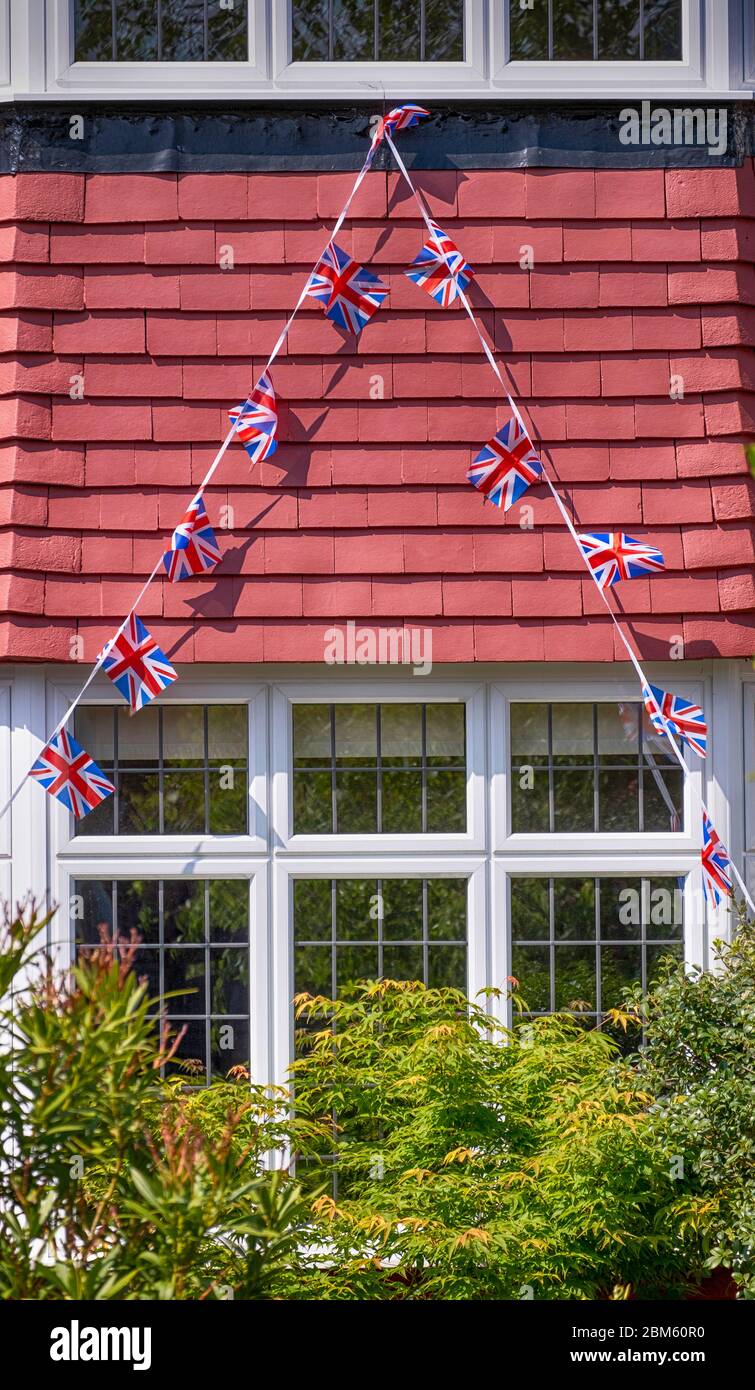 Morden, Surrey, Großbritannien. Mai 2020. Union Flag Bunting drapiert aus dem ersten Stock eines Hauses im Südwesten von London Borough of Merton zu feiern 75. Jahrestag des VE Day. Quelle: Malcolm Park/Alamy Live News. Stockfoto