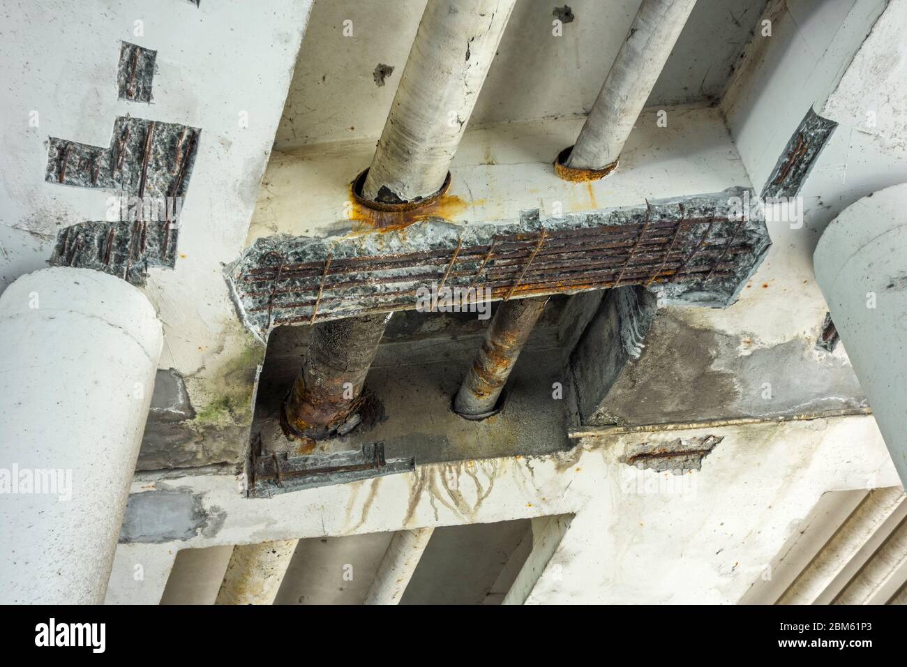 Reparaturarbeiten / Renovierung mit zerbröckeltem Beton und freiliegendem Stahlbeton bei Mariakerkebrug, 60er Jahre Brücke in Mariakerke, Ostflandern, Belgien Stockfoto