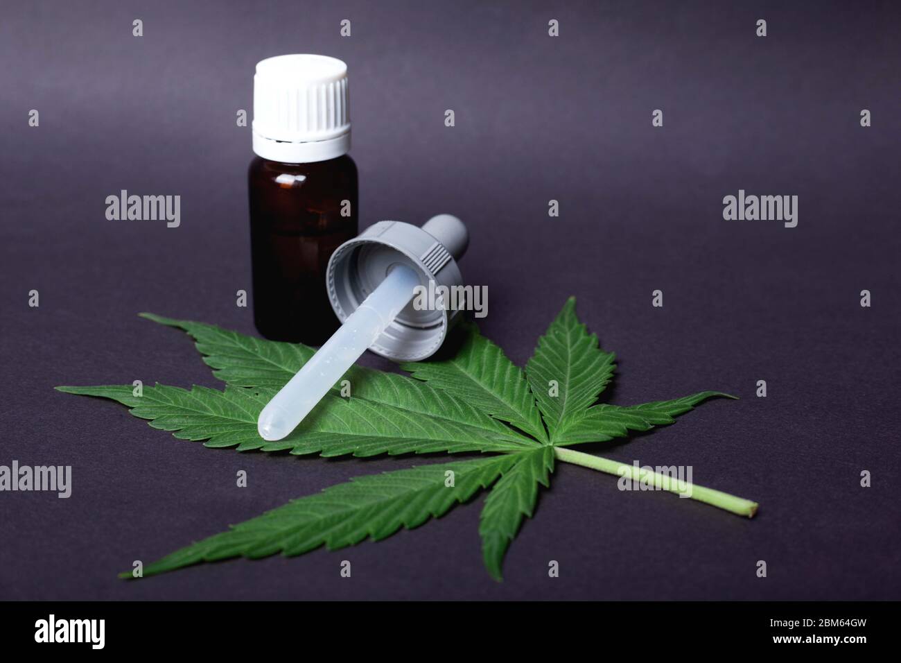Medizinisches Cannabis-Konzept, Marihuana-grünes Blatt und eine Pipette mit THC-Extrakt. Stockfoto