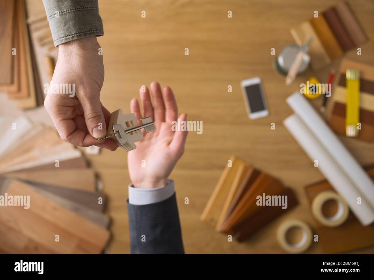Real Estate Agent geben Hausschlüssel mit arbeiten Werkzeuge und Desktop-Hintergrund, Ansicht von oben Stockfoto