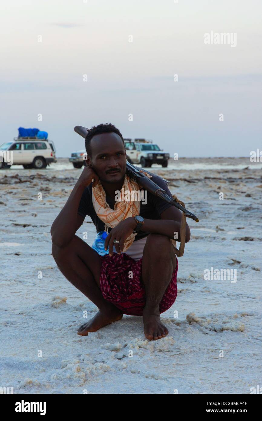Dallol, Äthiopien - Nov 2018: Kundschafter mit einem Gewehr posiert in der Danakil Wüste, Äthiopien. Pfadfinder sind obligatorisch, um Touristen in bestimmten Bereichen der zu begleiten Stockfoto Dallol, Äthiopien - Nov 2018: Kundschafter mit einem Gewehr posiert in der Danakil Wüste, Äthiopien. Pfadfinder sind obligatorisch, um Touristen in bestimmten Bereichen der zu begleiten Stockfoto