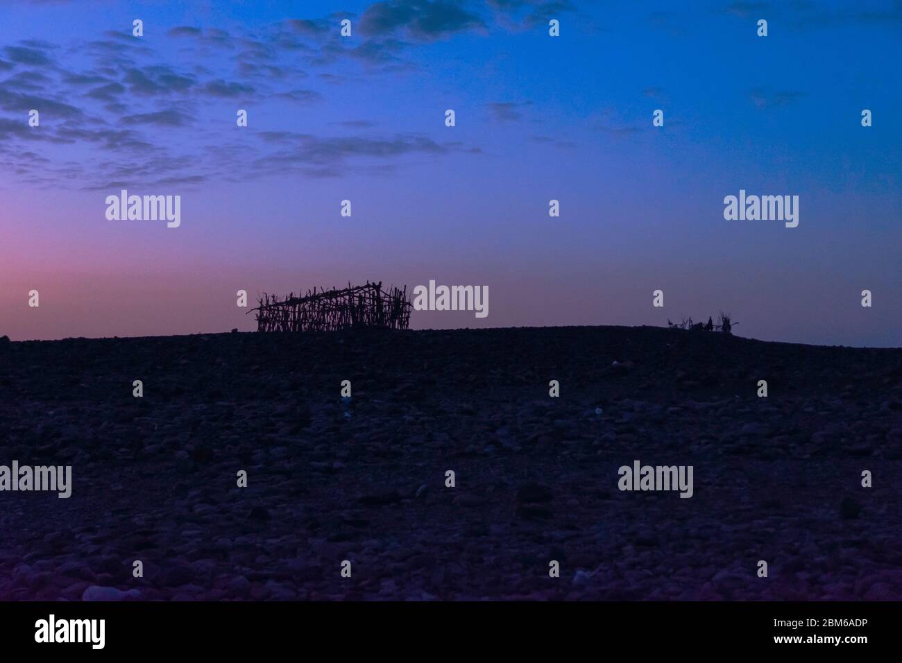 Silhouetten von Hütten in der Danakil Wüste in der Dämmerung, Äthiopien Stockfoto Silhouetten von Hütten in der Danakil Wüste in der Dämmerung, Äthiopien Stockfoto