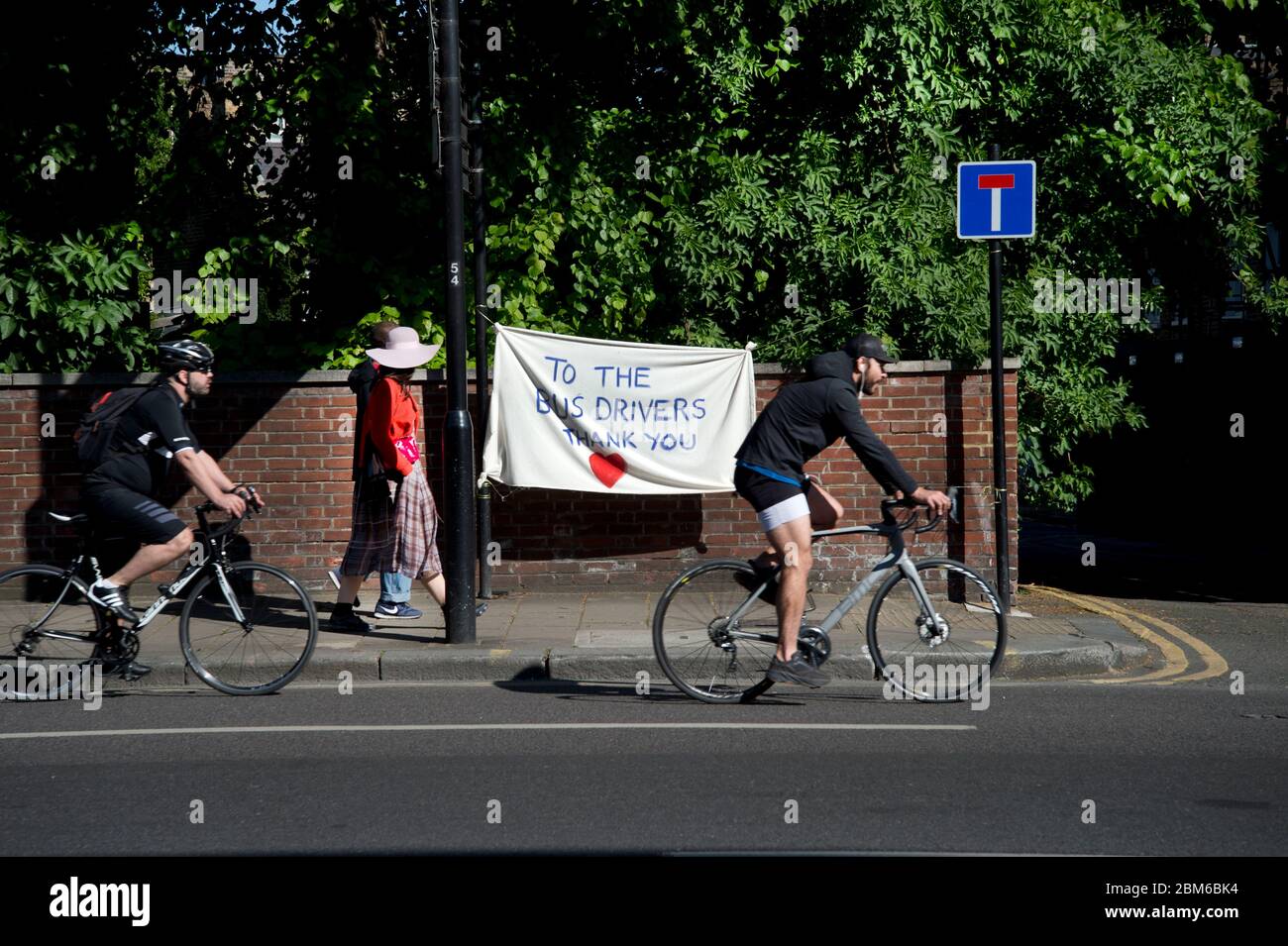 London Mai 2020 die Covid-19-Pandemie. Mare Street, Hackney. Radfahrer und Wanderer passieren ein Banner dank Busfahrer. Stockfoto
