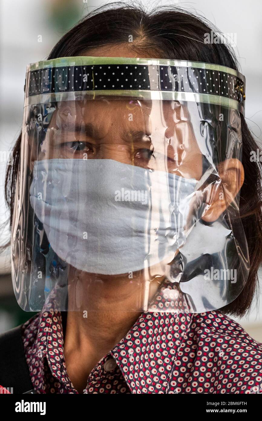 Lady mit selbstgemachter Gesichtsschutz und Maske während der Covid 19 Pandemie, Bangkok, Thailand Stockfoto