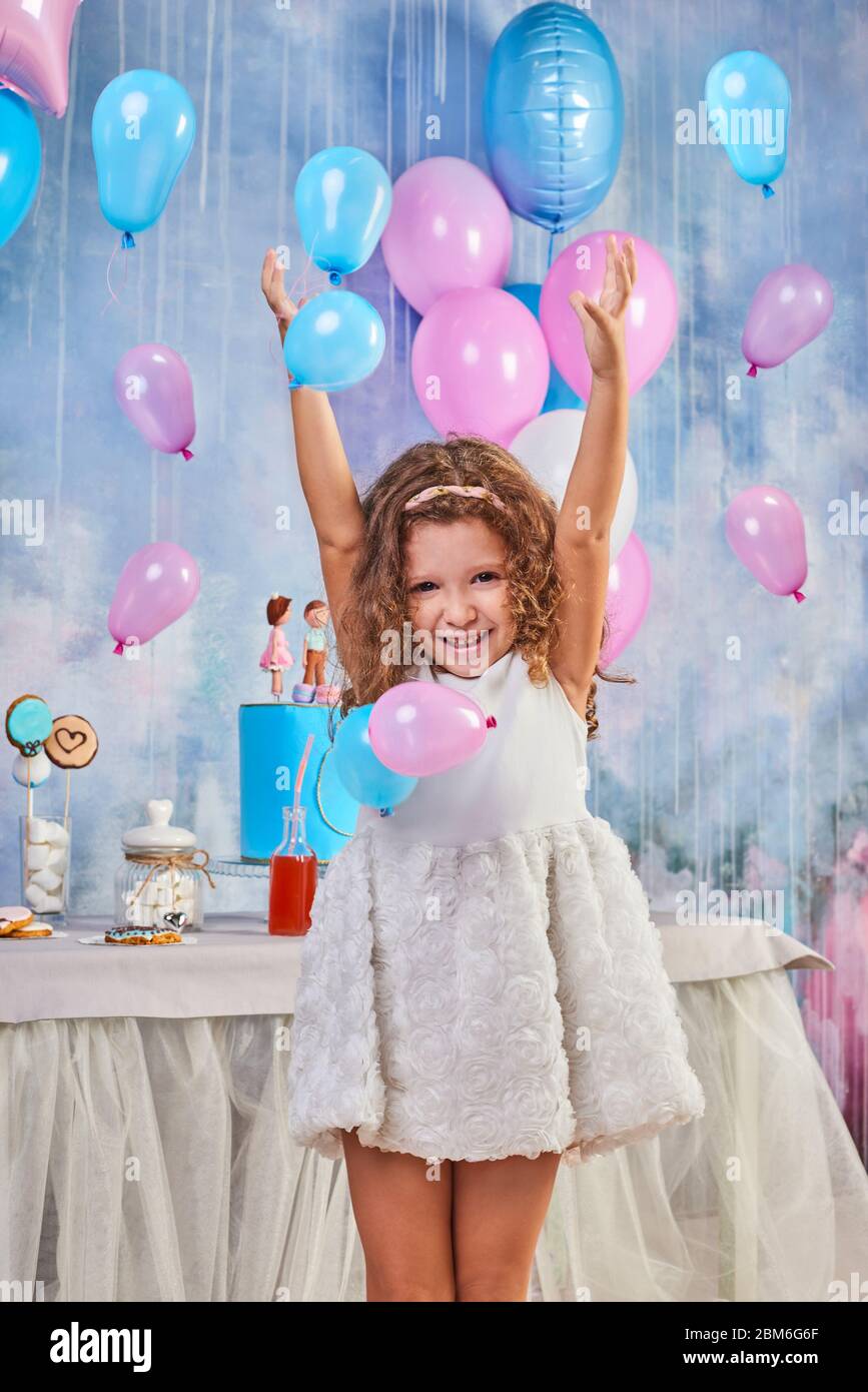 Lustige Geburtstagsfeier für Kinder im dekorierten Zimmer. Happy Little girl feiern den Internationalen Kindertag. Lustige Kinder spielen zu Hause Stockfoto