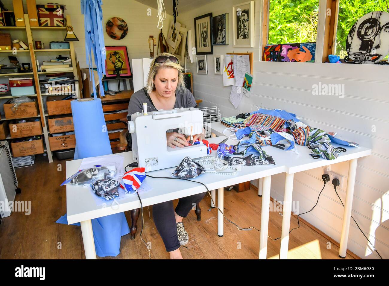 Die Künstlerin Shelley Dyer Gibbins, 47, aus dem Dorf Croscombe, in der Nähe von Wells, stellt in ihrem Atelier chirurgische Gesichtsmasken her, die mit bedrucktem Stoff bedeckt sind, und stellt für alle 600 Einwohner des Dorfes Somerset Designer-Gesichtsmasken her. Sowohl aus medizinischem Maskenmaterial als auch aus einigen ihrer Kunstdruckmaterialien hatte sie übrig. Stockfoto