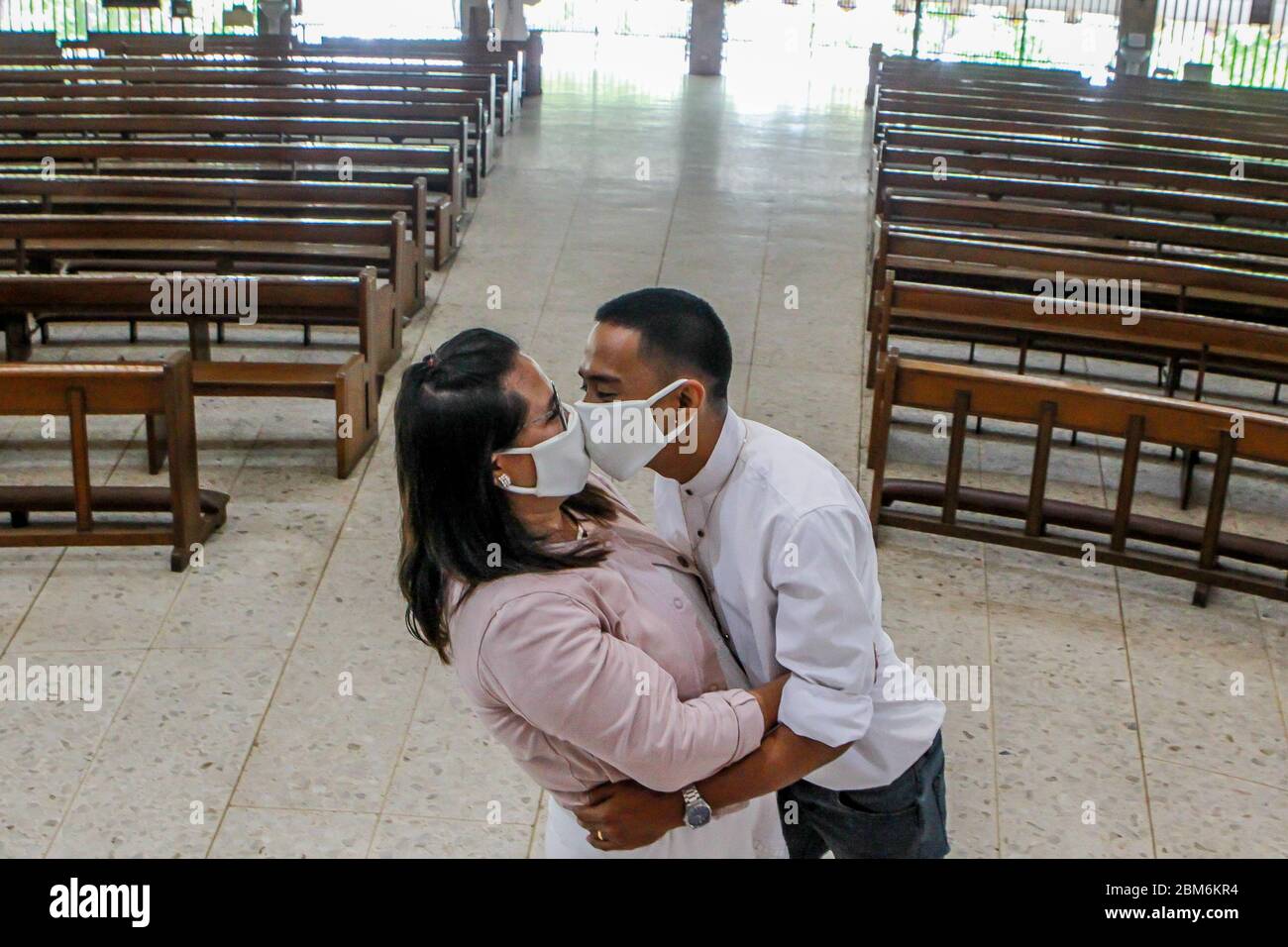 Quezon City, Philippinen. Mai 2020. Ein frisch vermähltes Paar mit Gesichtsmasken küsst sich während einer Hochzeitszeremonie in Quezon City, Philippinen, am 7. Mai 2020. Die Philippinen meldeten am Donnerstag 339 neue COVID-19-Fälle, wodurch die Gesamtzahl der COVID-19-Fälle im Land auf 10,343 erhöht wurde. Quelle: Rouelle Umali/Xinhua/Alamy Live News Stockfoto