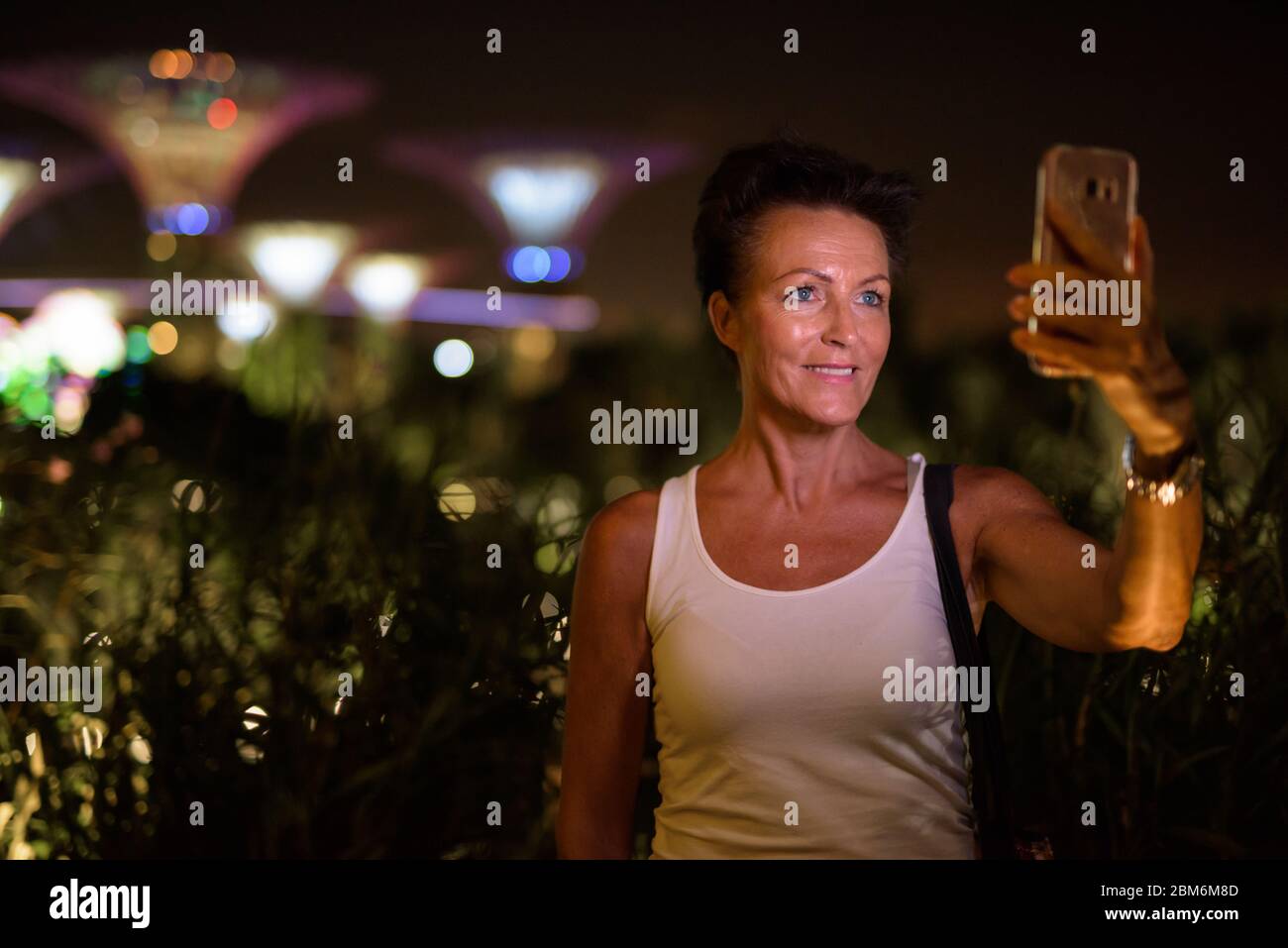 Glücklich reifen schöne touristische Frau, die Selfie in der Stadt bei Nacht Stockfoto