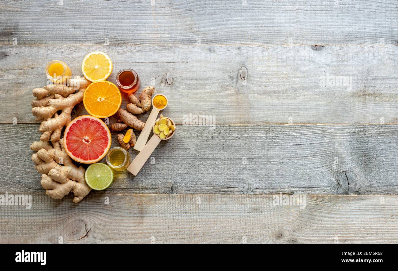 Draufsicht auf den Booster des Immunsystems - Ingwer, Kurkuma, Zitrusfrüchte und Honig auf dem alten Holzbrett Stockfoto