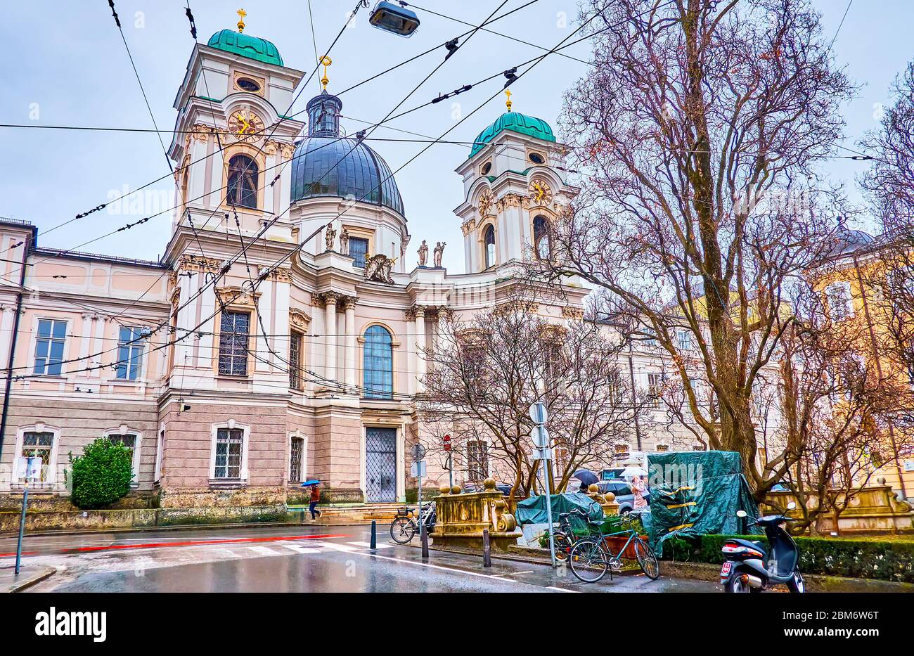 SALZBURG, ÖSTERREICH - 1. MÄRZ 2019: Die prächtige Dreifaltigkeitskirche mit halbrunden Haupteingangstor mit zwei Glockentürmen asides, am 1. März in Stockfoto