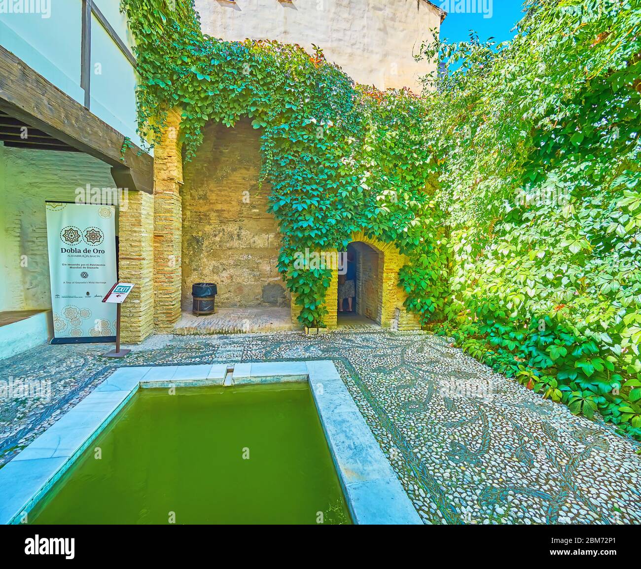 GRANADA, SPANIEN - 25. SEPTEMBER 2019: Der Innenhof von El Banuelo (Arabische Bäder, Hammam) mit einem Pool, landschaftlich reizvoller Boden mit Blumenmuster und Weinreben auf Stockfoto