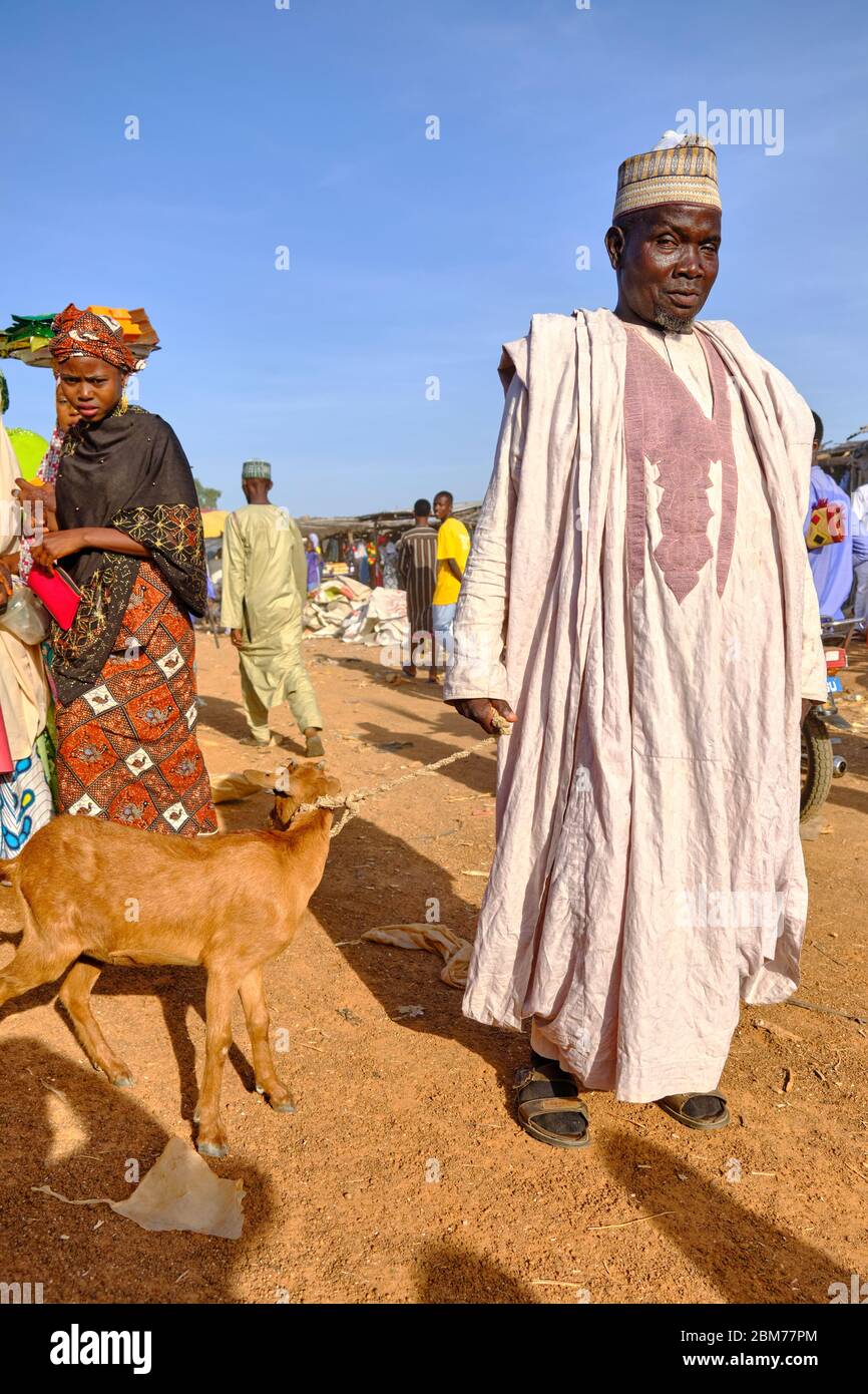 Muslimischer Mann mit einer Ziege an einem Seil auf dem Mahuta-Markt gebunden. Stockfoto