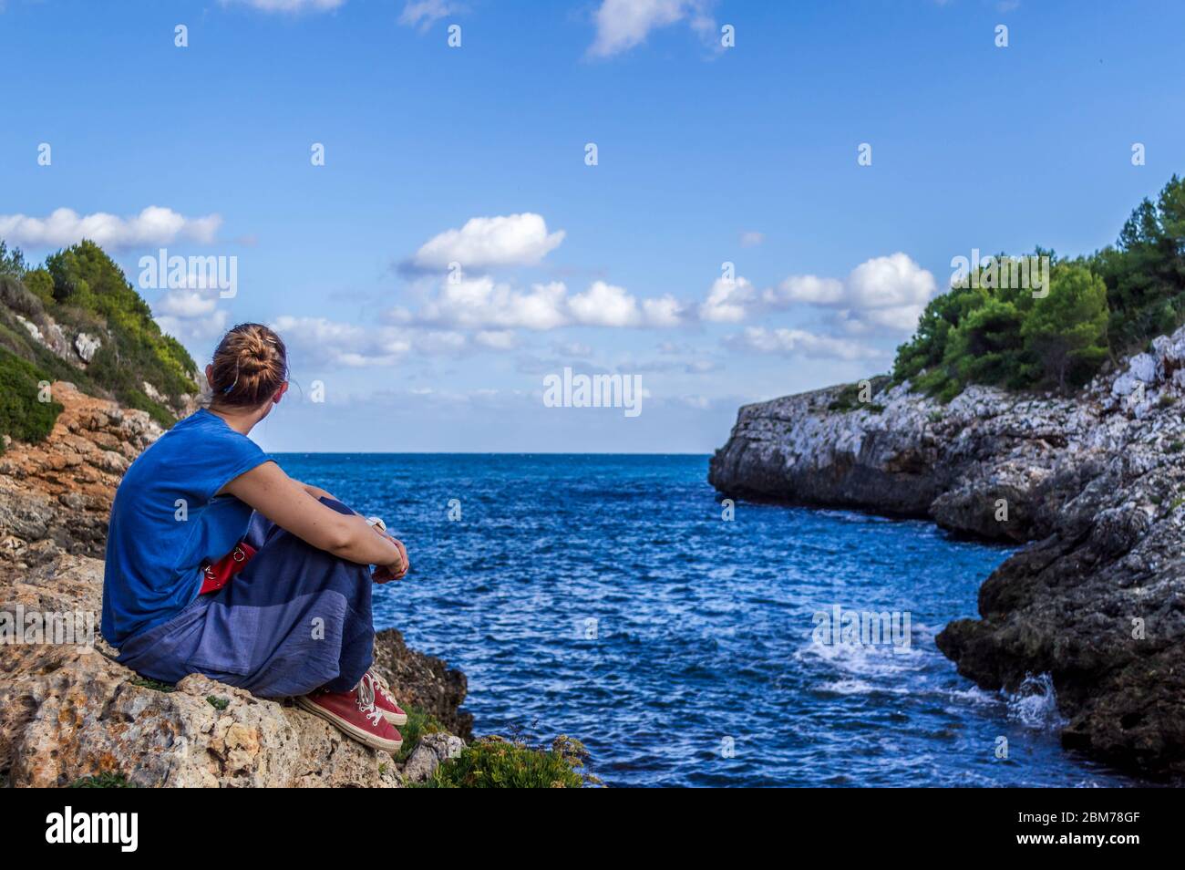 Ein Mädchen, das von der Schönheit der Landschaft in Cala Murta, Palma de Mallorca überrascht Stockfoto