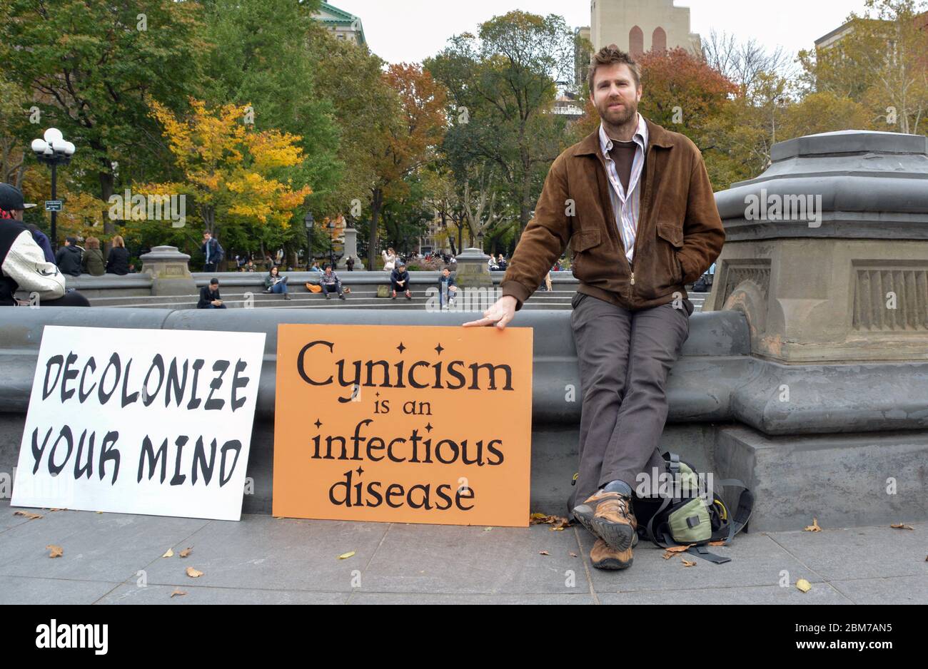 Ein Konzeptkünstler posiert mit geheimnisvollen Zeichen in der Nähe des Brunnens im Washington Square Park in Greenwich Village, New York City. Stockfoto