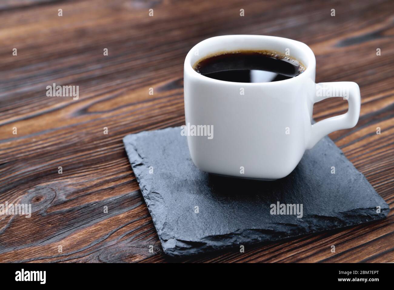 Weiße Tasse Kaffee auf einem Steinständer, Holz natürlichen Hintergrund close-up Kopie Raum Stockfoto