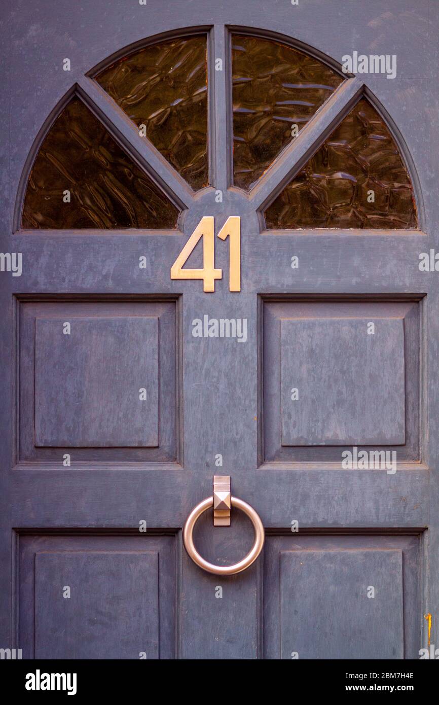 Die Hausnummer 41 auf der hölzernen Vordertür unter dem Halbkreis des Glases Stockfoto