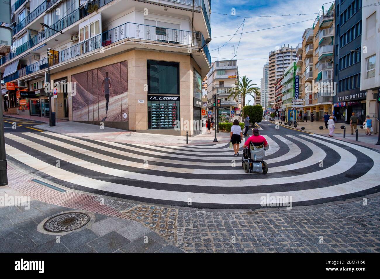 Benidorm, Alicante, Spanien, 4.5.2020, übergroßer Fußgängerüberweg markiert einen Fußgängerübergang in der Kurve einer Straße im Einkaufsviertel Stockfoto
