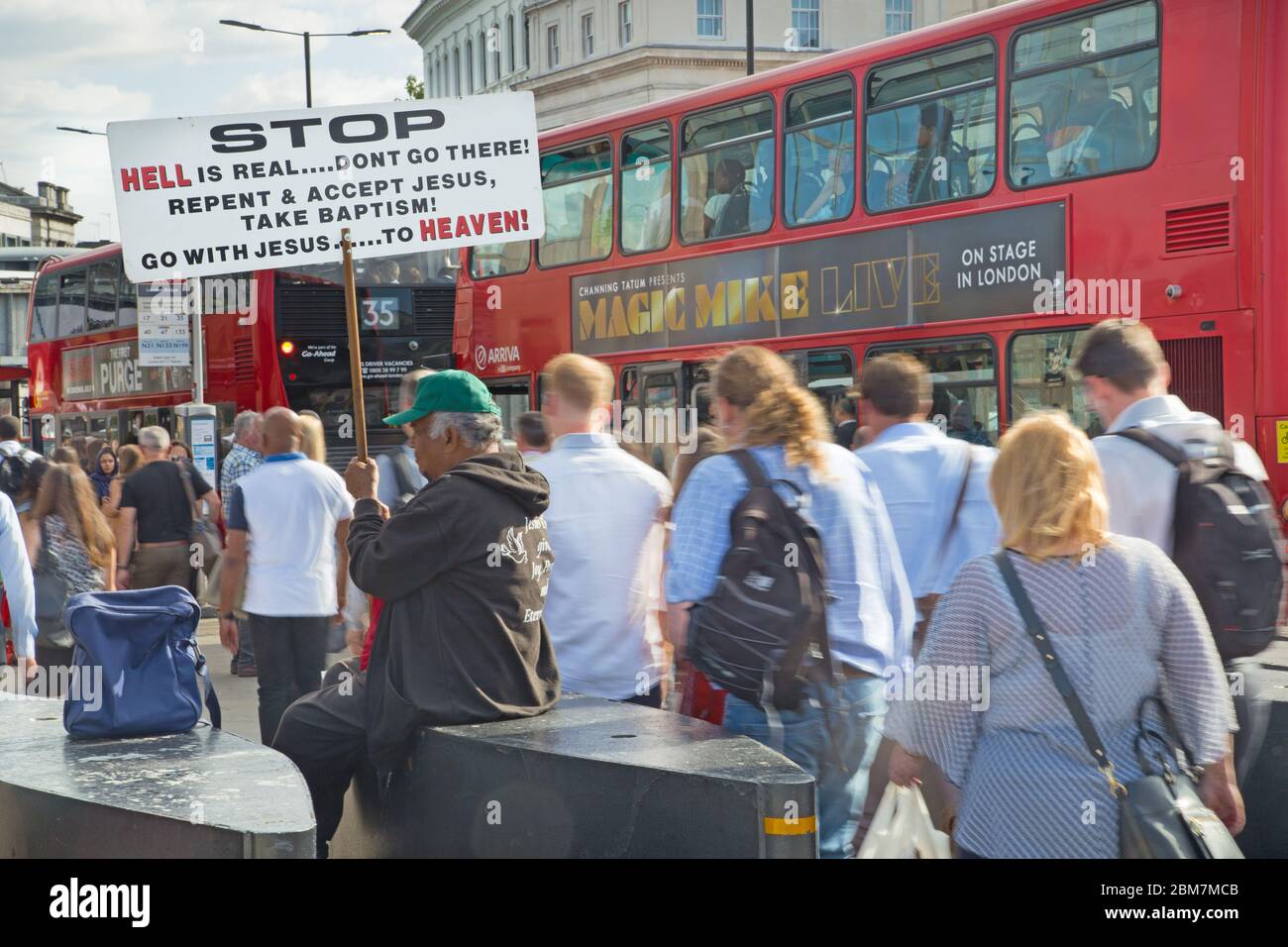 Ein evangelikaler Christ hält ein Schild, das die Menschen dazu auffordert, Buße zu tun und mit Jesus zu gehen, während Pendler auf dem Heimweg über die London Bridge, Großbritannien, vorbeiströmen Stockfoto