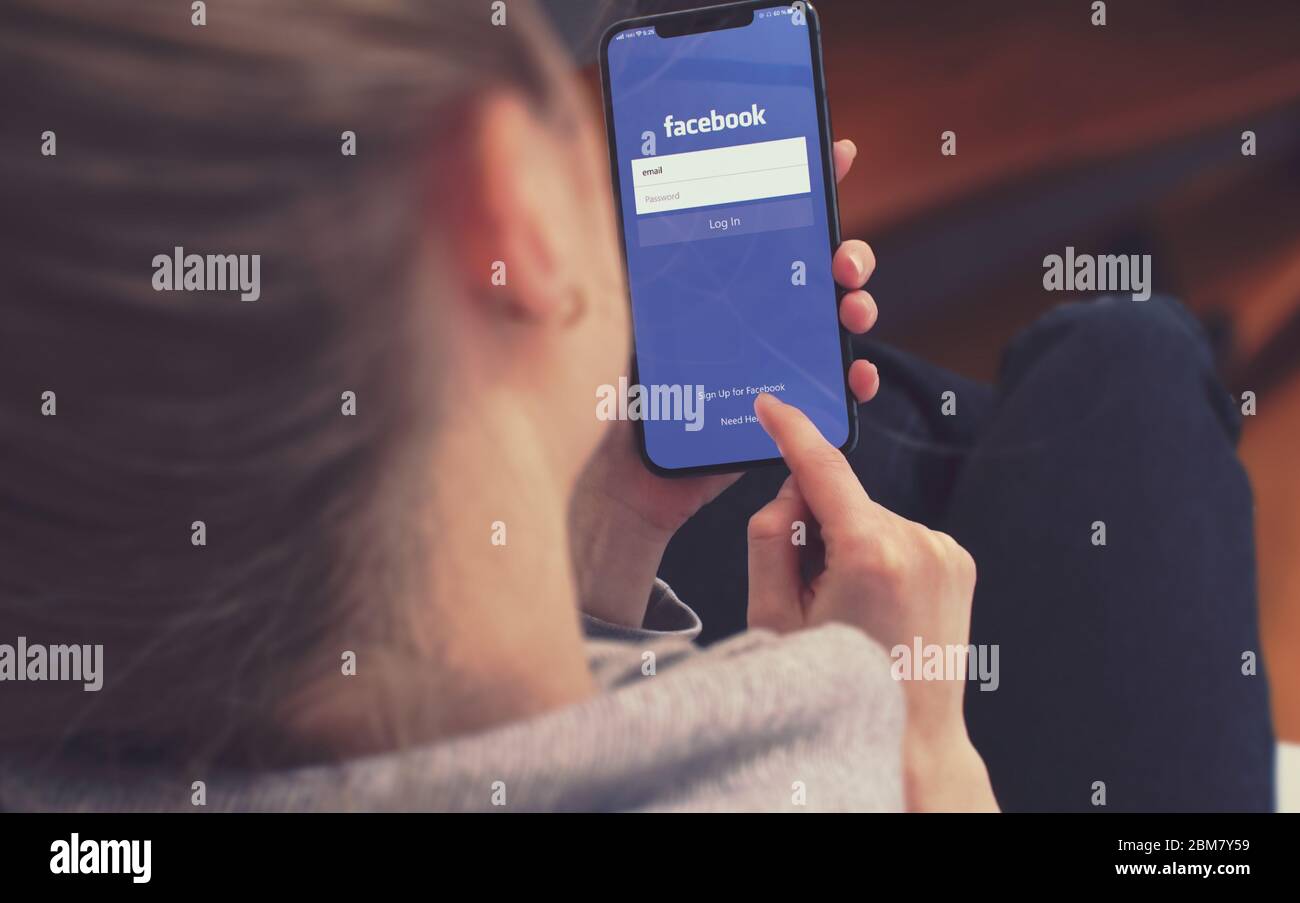 KIEW, UKRAINE-JANUAR 2020: Facebook auf dem Smartphone-Bildschirm. Junges Mädchen zeigt auf Facebook auf dem Smartphone während einer Pandemie Selbstisolierung und Coronavirus-Prävention. Stockfoto