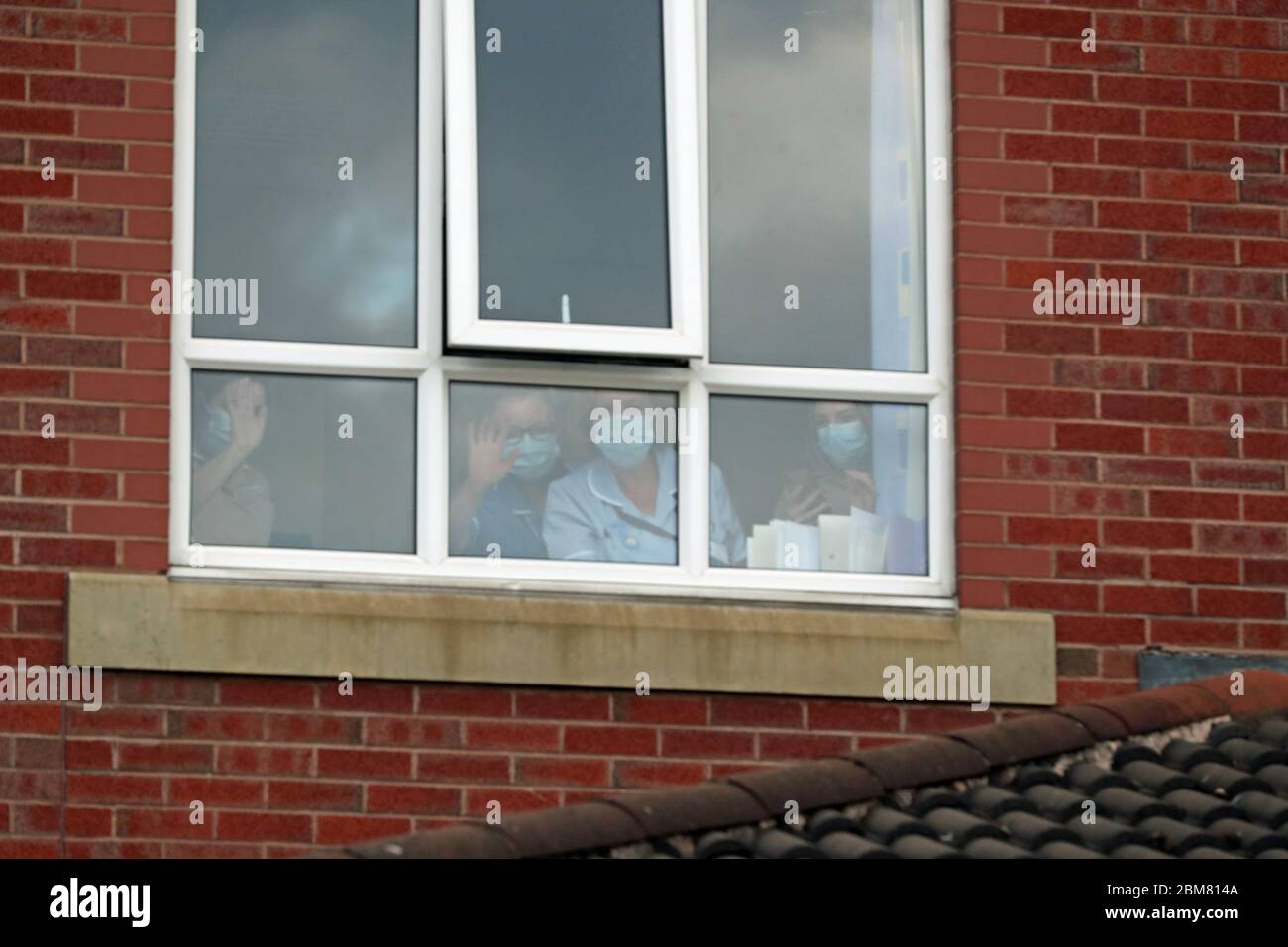 Das Pflegepersonal, das durch ein Fenster im Trafford General Hospital in Manchester schaut, applaudiert am Donnerstag beim landesweiten Clap für Pfleger, um NHS-Mitarbeiter und Pfleger zu erkennen und zu unterstützen, die gegen die Coronavirus-Pandemie kämpfen. Stockfoto