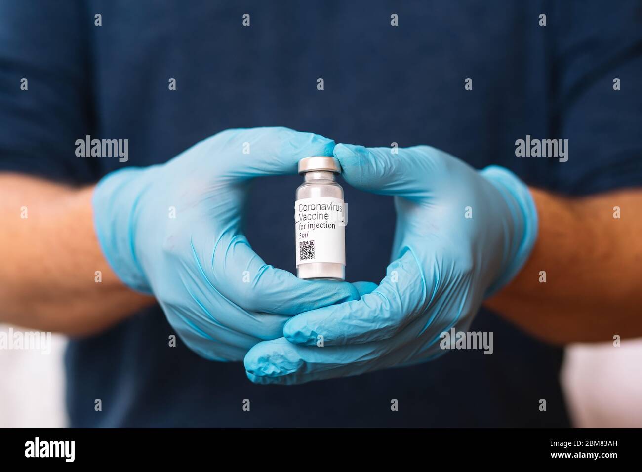Coronavirus-Impfstoff. Arzt mit Impfstoff. Hände, die eine Ampulle gegen Covid-19 halten. Stockfoto