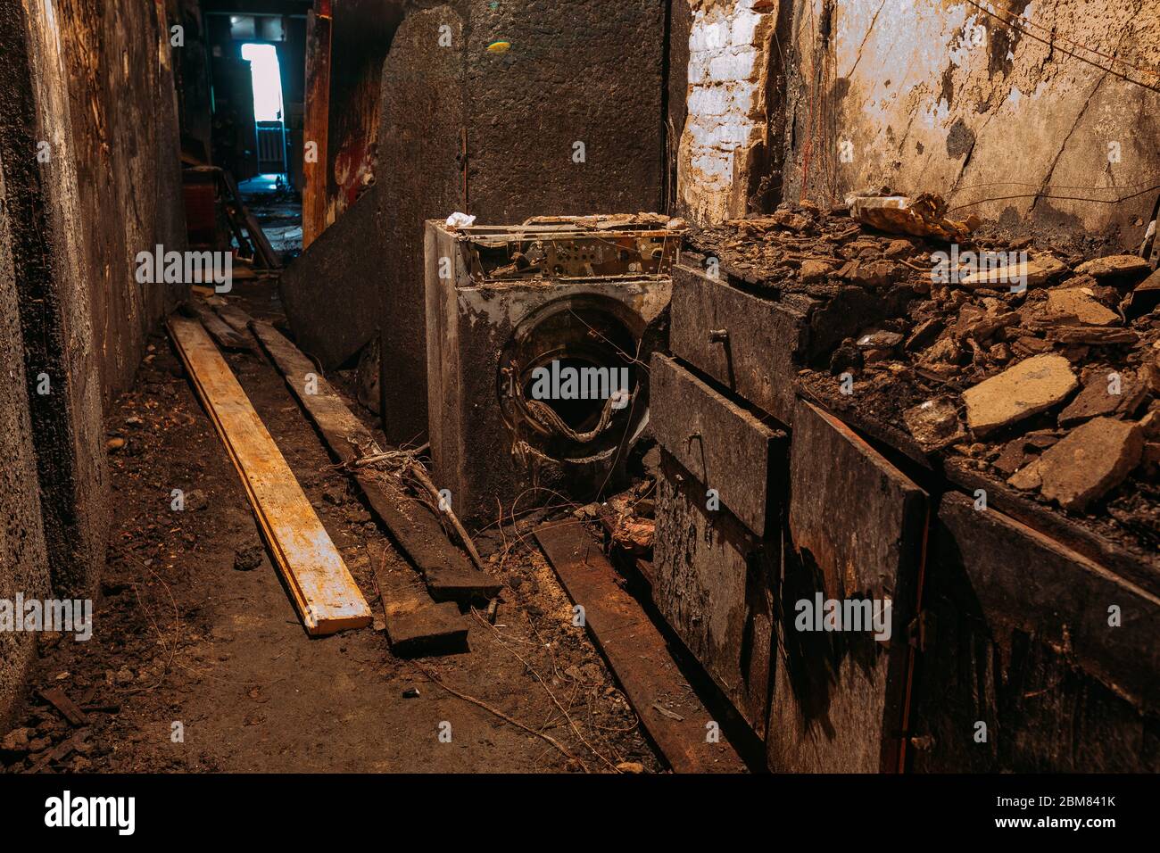 Verbrannte Hauseinrichtung. Verbranntes Badezimmer, verbrannte Reste von Möbeln und Waschmaschine Stockfoto