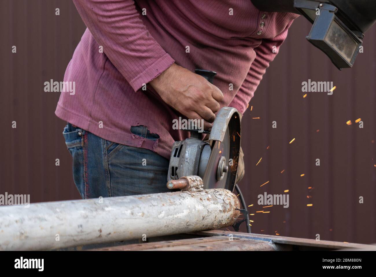 Reinigung von Metallkonstruktionen mit einem Winkelschleifer, gefährliche Arbeit für unsere Augen Stockfoto