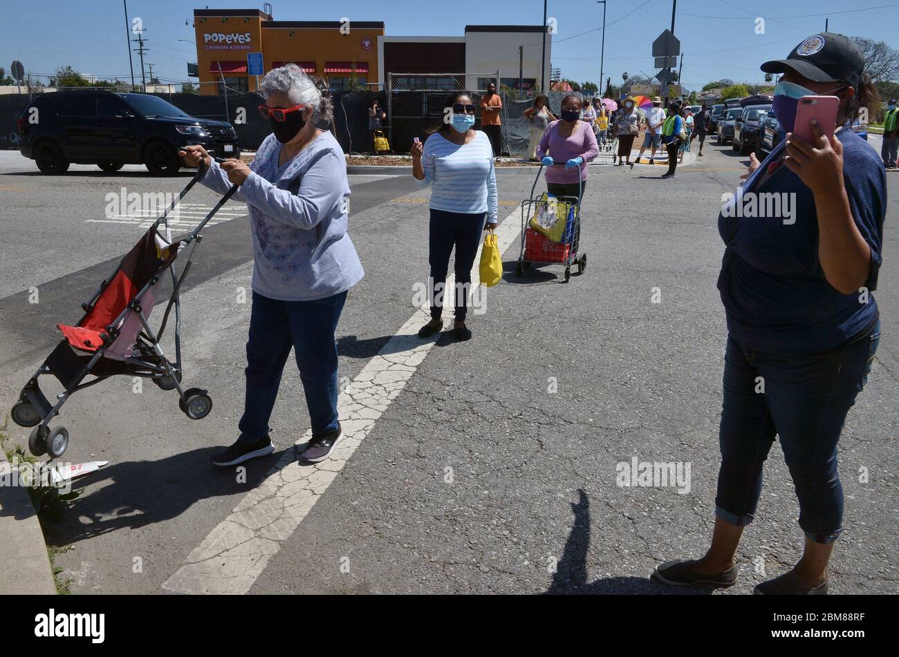 Los Angeles, USA. Mai 2020. Fahrzeuge und Fußgänger stehen für ein Virtual Drive-Thru und Walk-Up Giveaway, das vom United Hands Multi-Purpose Center gesponsert wird, um Tausende von Einwohnern von South L.A. während der COVID-19-Pandemie in Compton, Kalifornien, am Samstag, den 2. Mai 2020 zu ernähren. Das US-Landwirtschaftsministerium hat einen Plan angekündigt, mehr Nahrungsmittel von kämpfenden Bauern zu kaufen und an Lebensmittelbanken zu verteilen - diesmal rund 470 Millionen Dollar. Quelle: UPI/Alamy Live News Stockfoto