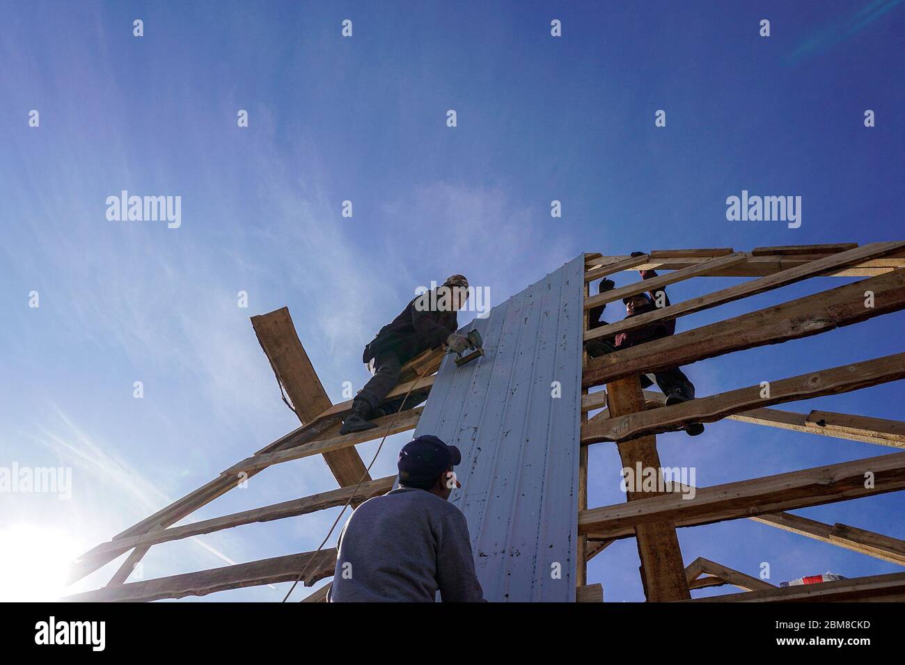 Die Zimmerleute Tumennasan Lkhagvadorj, unten, Battoktok Galbadrakh, oben links, und Nyamdorj Baasanjav bauen das Dach eines neuen Hauses in Murun, einem Bezirk in der mongolischen Provinz Khuvsgul. (Dolgormaa Sandagdorj, GPJ Mongolei) Stockfoto