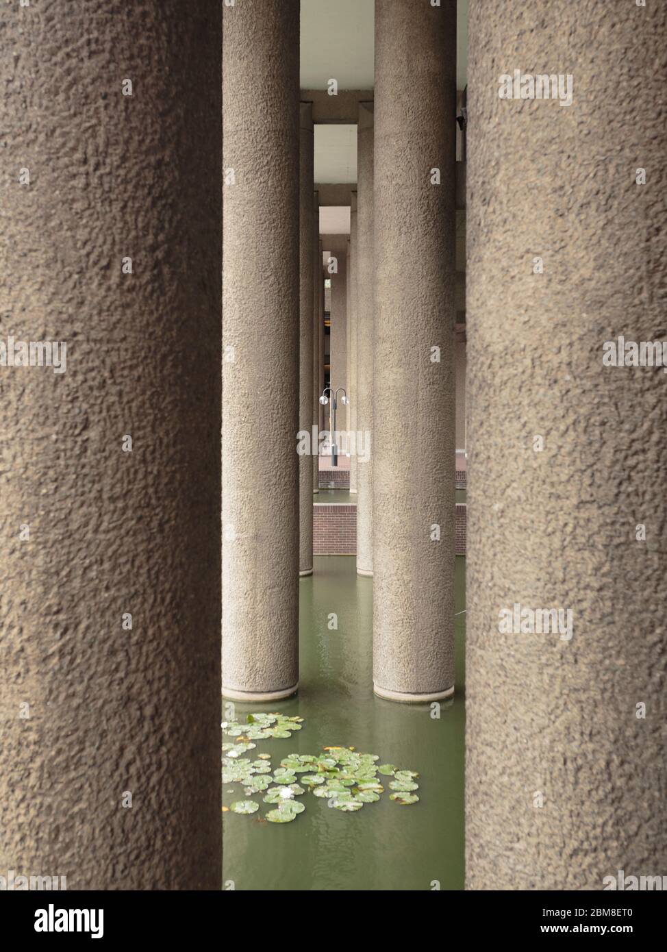 Laternenpfosten zwischen Säulen im Barbican Centre, London, England Stockfoto
