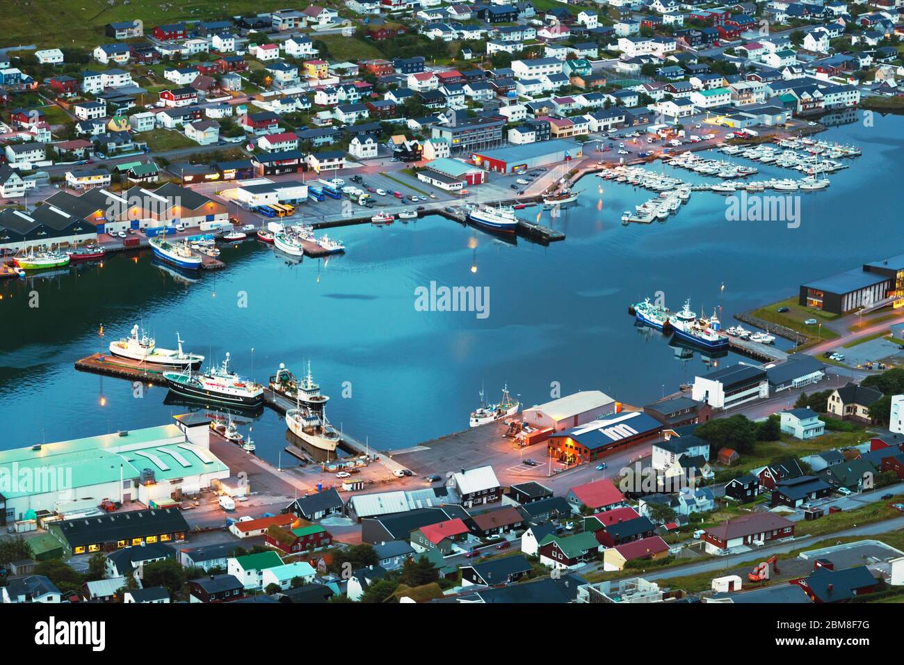 Atemberaubende Abendstadtbild von Klaksvik Stadt mit Fjord, Pier, Schiffe und Boote, Bordoy Insel, Färöer Inseln, Dänemark. Landschaftsfotografie Stockfoto