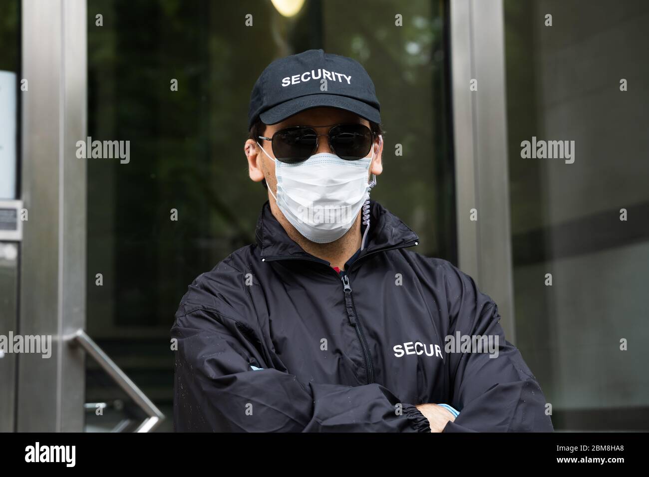 Sicherheitswache Im Gesicht Maske Am Eingang Stockfoto