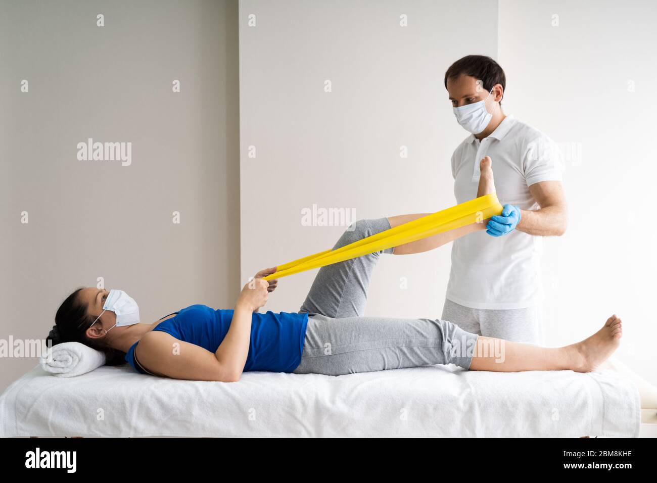 Physiotherapeut Doing Band Übung Therapie Und Therapie In Gesichtsmaske Stockfoto