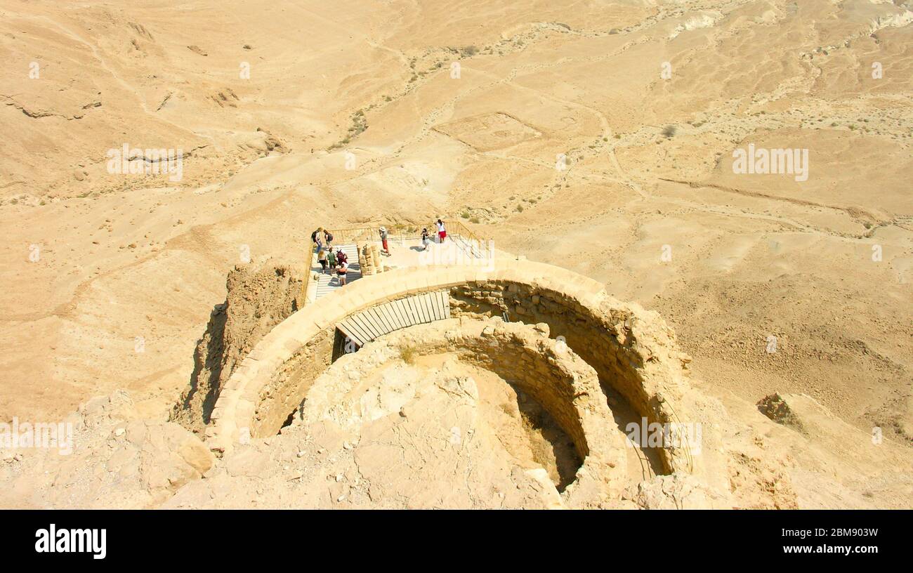 Masada, ein berühmter Touristenort in Israel aus der Luft mit Touristen am Rande mit Blick aus., umgeben von Sand in der Wüste. Stockfoto