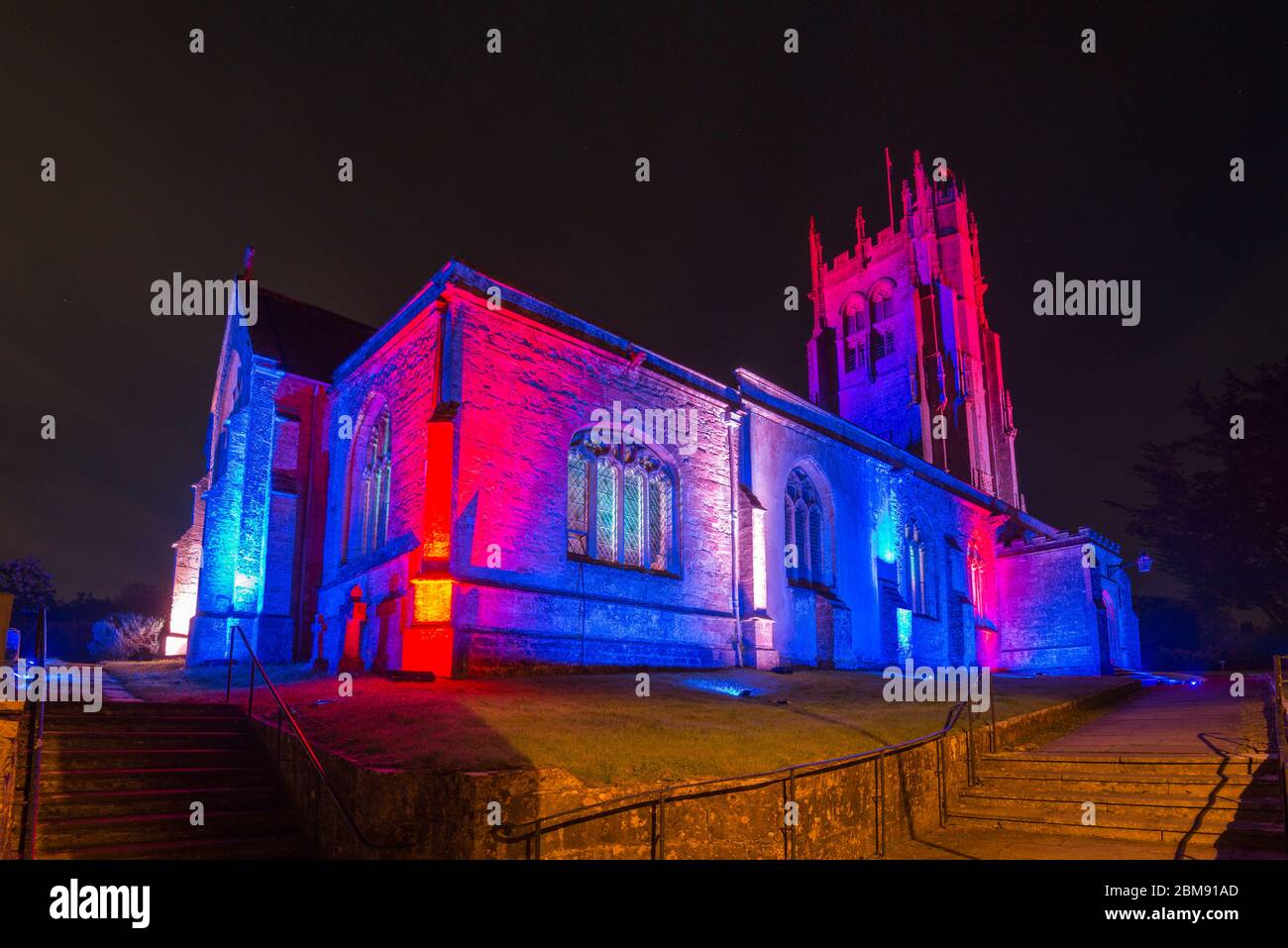 Beaminster, Dorset, Großbritannien. Mai 2020. St. Mary’s Church in Beaminster in Dorset leuchtet rot, weiß und blau zum 75. Jahrestag des VE Day. Bild: Graham Hunt/Alamy Live News Stockfoto