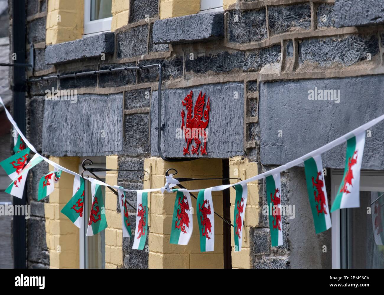 Traditionelle Welsh Bunting und Red Welsh Dragon auf der Tür in Penmachno, Penmachno, Snowdonia, North Wales, Großbritannien Stockfoto