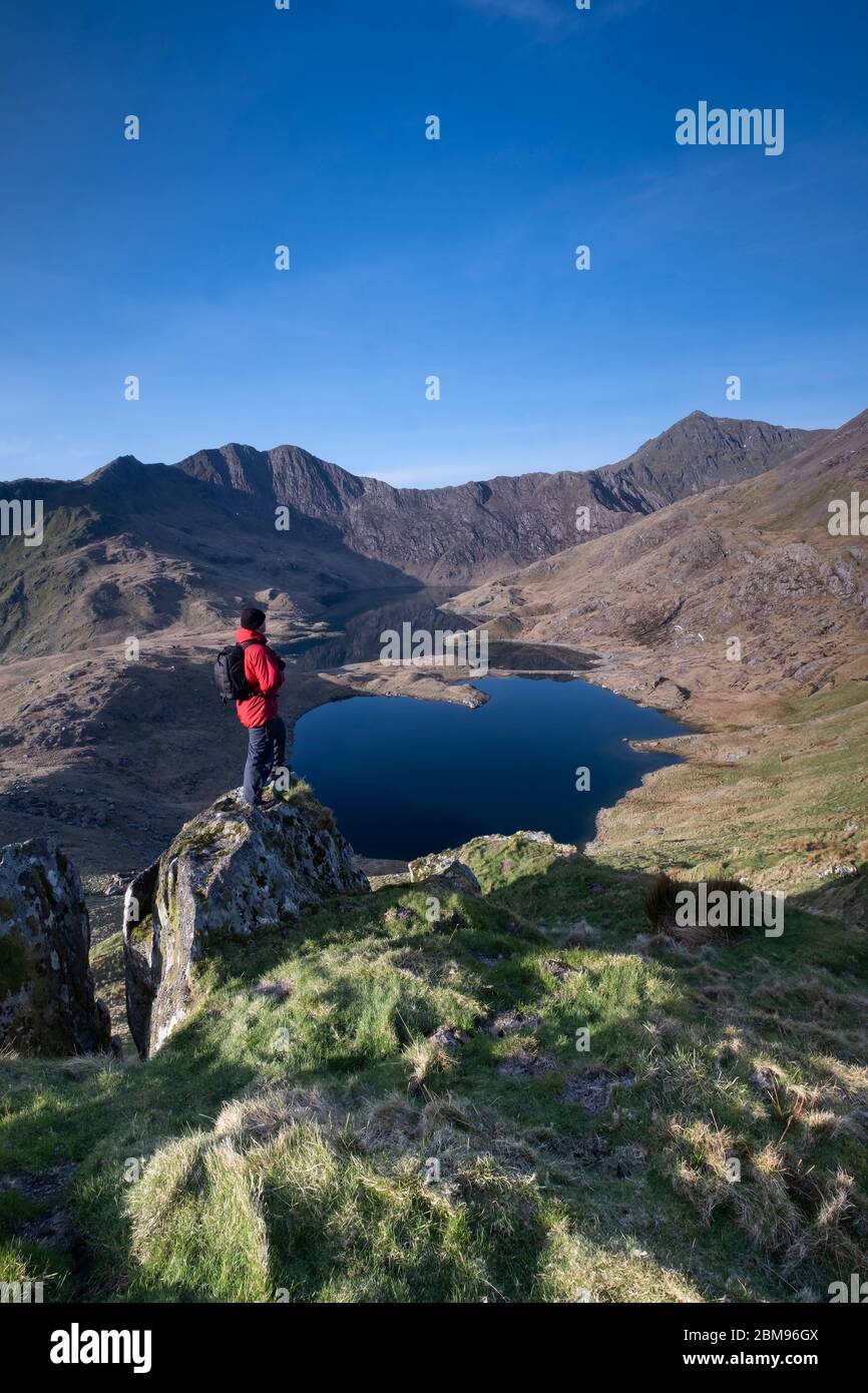 Walker auf den Hörnern über Cwm Dyli, Llyn Llydaw, Mount Snowdon & The Snowdon Horseshoe, Snowdonia National Park, North Wales, UK MODELL VERÖFFENTLICHT Stockfoto
