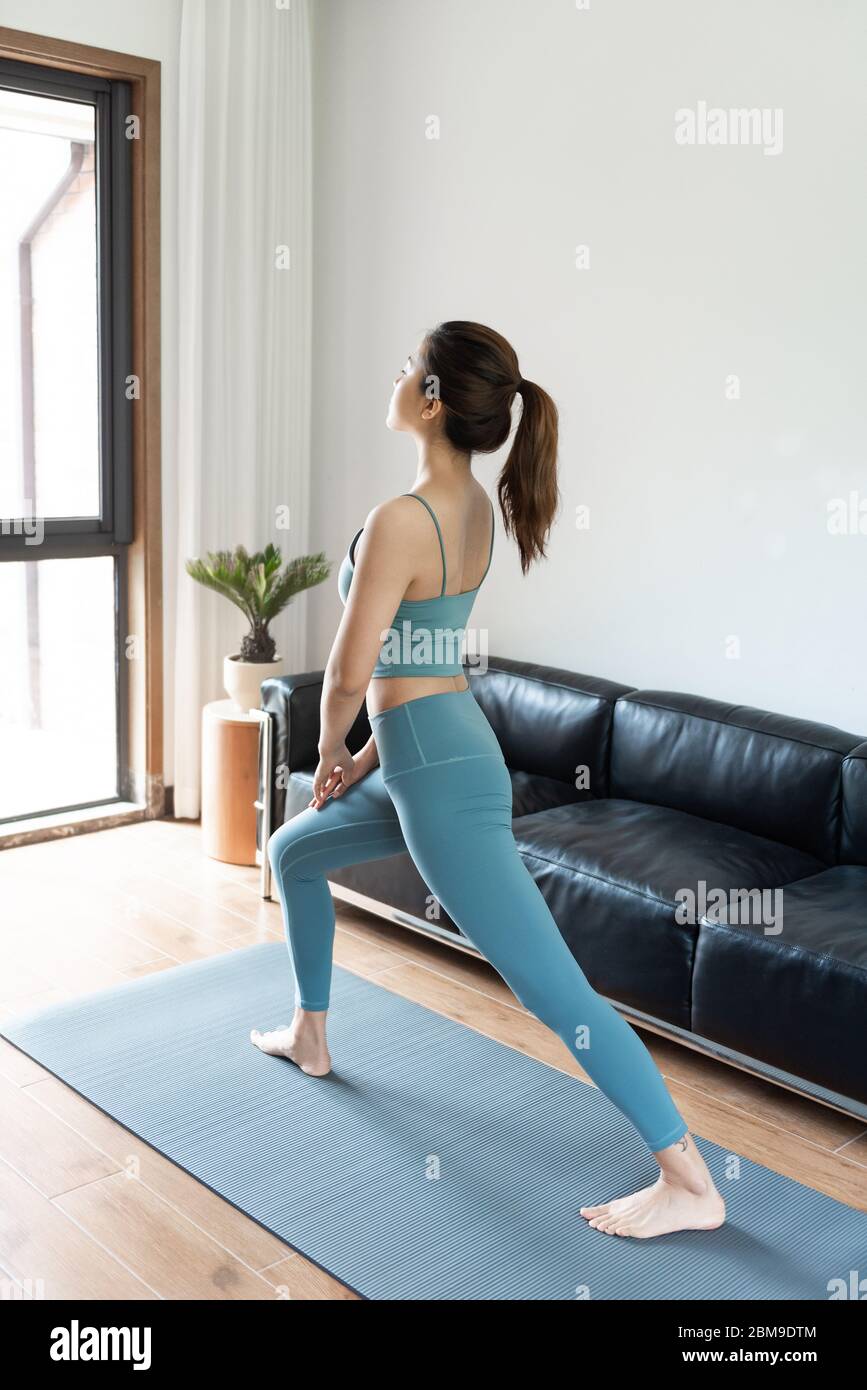 Eine junge asiatische Frau, die zu Hause Yoga macht Stockfoto