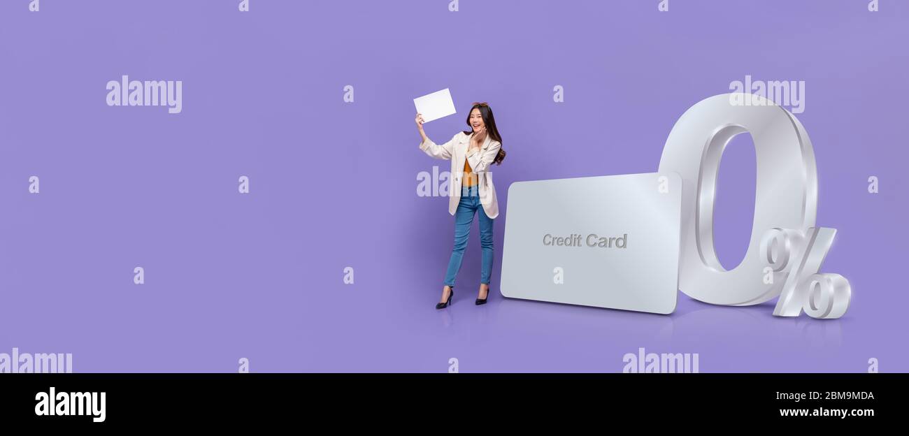 Lächelnd glücklich asiatische Frau mit weißem Papier stehen neben Kreditkarte mit 0% Zinsen Ratenzahlung Förderung gegen lila Banner backgr Stockfoto