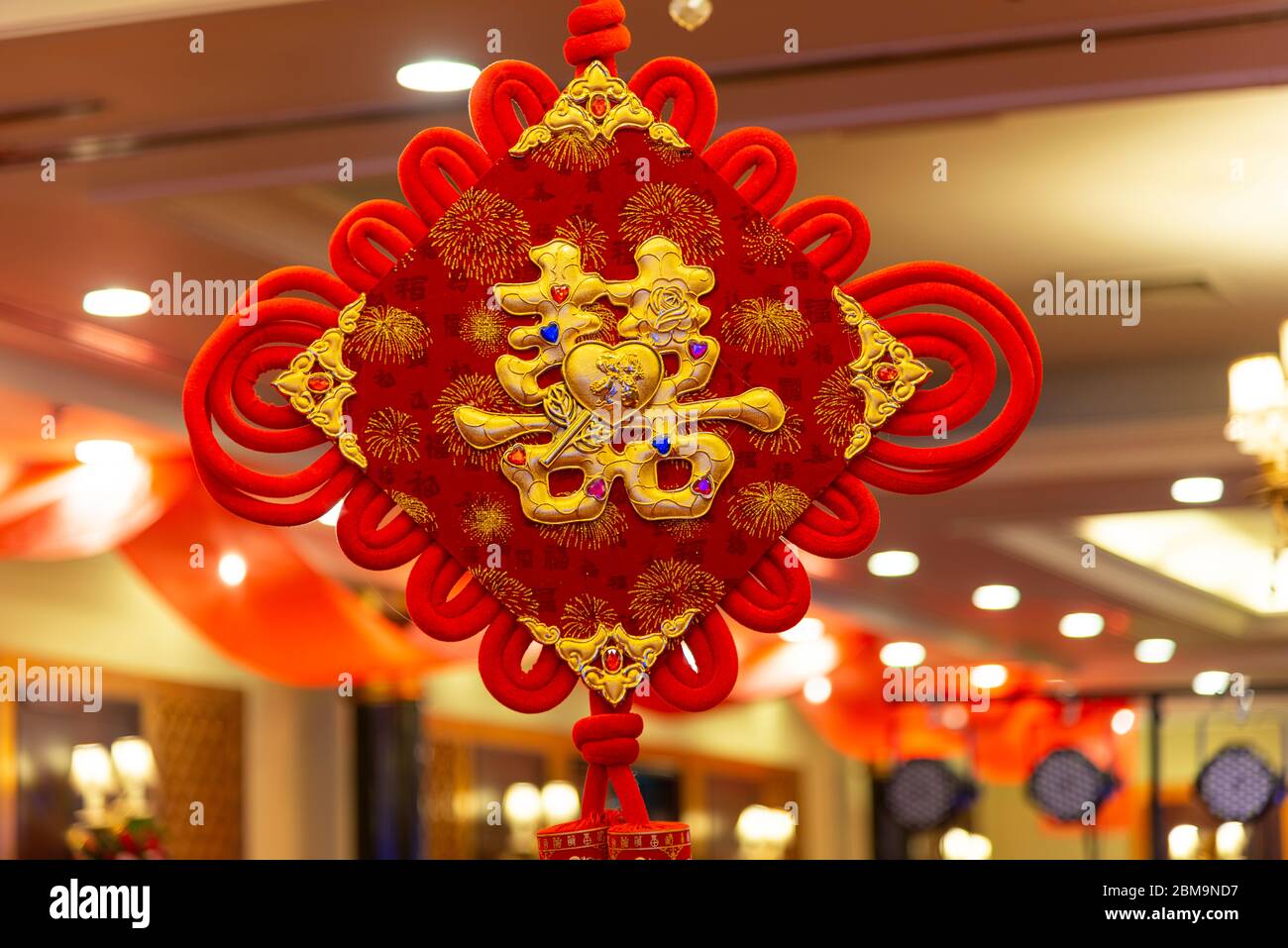 Ein chinesisches Wort Glück Stickerei auf chinesischen Knoten. Chinesisches Wort bedeutet: In der Ehe grüßen Männer und Frauen gemeinsam einen glücklichen Tag Stockfoto