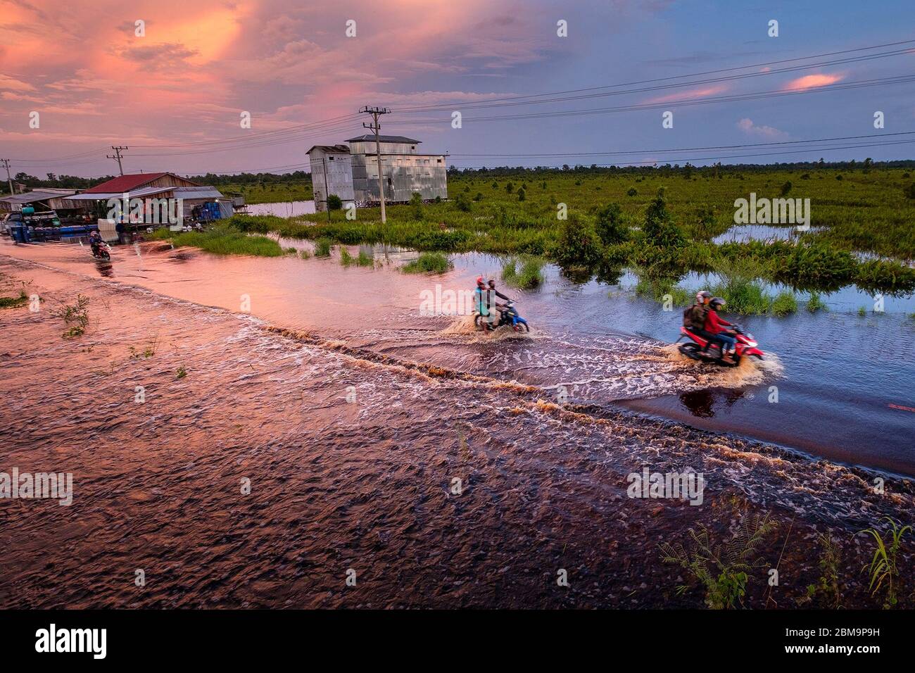 Peking, Indonesien. Mai 2020. Im Dorf Bukit Rawi im Zentrum von Borneo, Indonesien, fahren Menschen mit dem Motorrad durch das Flutwasser, 7. Mai 2020. Kredit: Deny Krisbiantoro/Xinhua/Alamy Live News Stockfoto