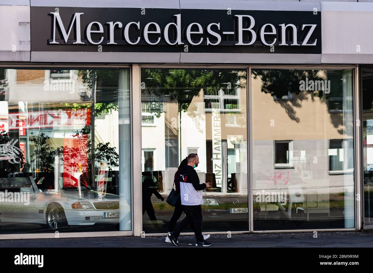 Berlin, Deutschland. Mai 2020. Fußgänger laufen an einem Autohaus von Mercedes-Benz in der deutschen Hauptstadt Berlin, 7. Mai 2020 vorbei. Der Autoexport in Deutschland sei "fast zum Stillstand gekommen", so der Verband der Automobilindustrie (VDA). Im April wurden weltweit nur 17,600 neue Pkw an Kunden ausgeliefert, die um 94 Prozent gesunken sind. Kredit: Binh Truong/Xinhua/Alamy Live News Stockfoto