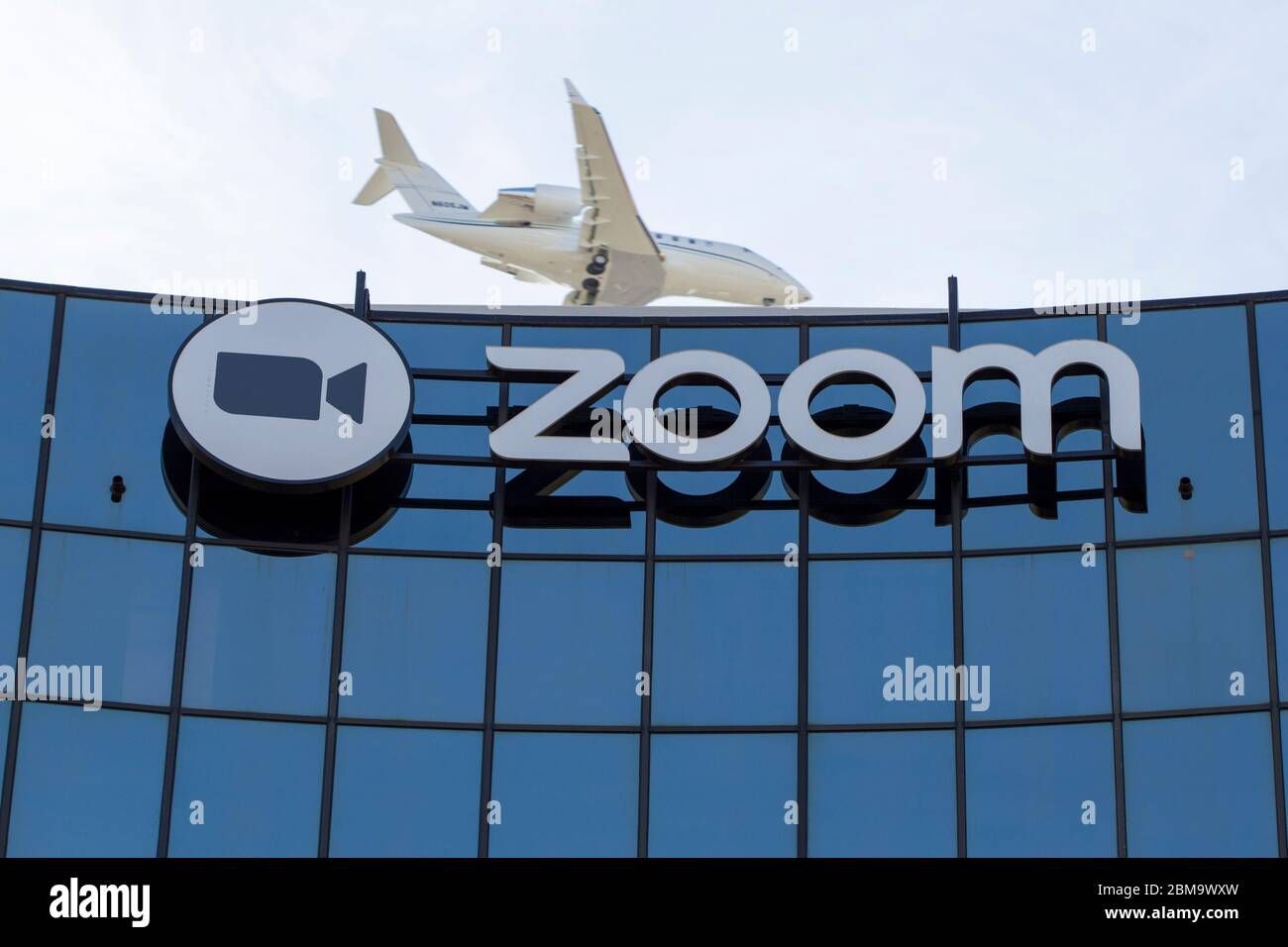 Ein Flugzeug fliegt über die Zoom Video Communications Zentrale in der Innenstadt von San Jose, Kalifornien. Stockfoto